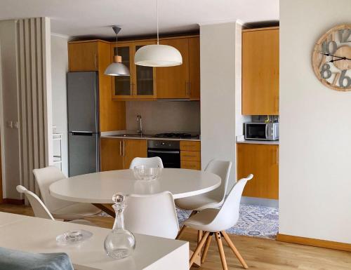 a kitchen and dining room with a white table and chairs at nearsea in Lavra
