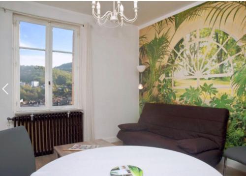 un salon avec un canapé et une fenêtre dans l'établissement Joli appartement avec vue, idéal pour votre cure, à Royat