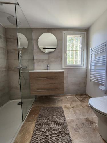 une salle de bain avec une douche, un lavabo et un miroir dans l'établissement villa de la mer, à Conca