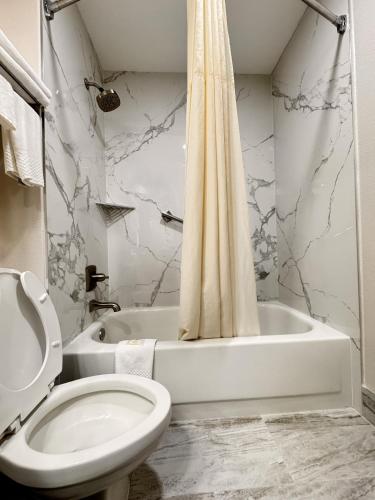 a bathroom with a toilet and a bath tub with a shower curtain at Quality Inn Cleveland North in Cleveland
