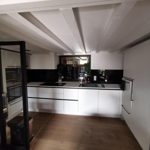 une grande cuisine avec des placards blancs et une grande fenêtre dans l'établissement Exceptional T3 with terrace in hypercentre, à Toulouse