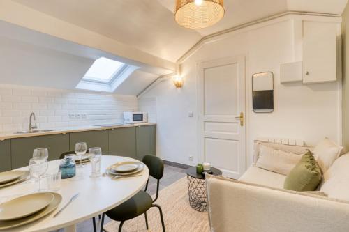 une cuisine et un salon avec une table et un canapé dans l'établissement T3 apartment just outside Paris, à Cachan