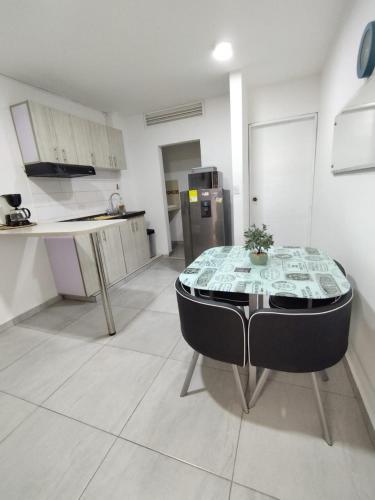 a room with a table and a kitchen with a counter at Ingenio Park 83 - Apartahotel in Cali