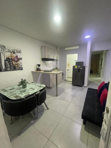 a living room with a table and a kitchen at Ingenio Park 83 - Apartahotel in Cali