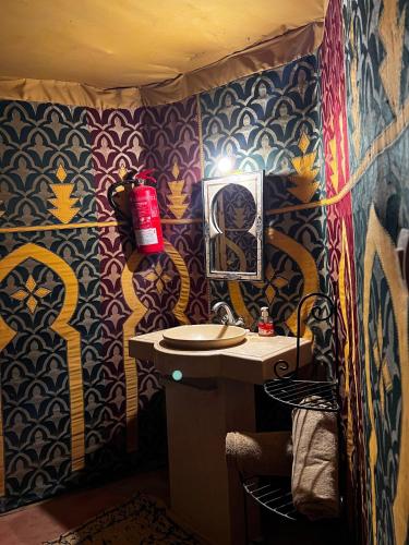 a bathroom with a sink and a mirror at Nomada Desert Camp in Merzouga