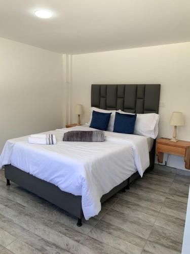 a bedroom with a large bed with blue pillows at Destino Real in Jericó