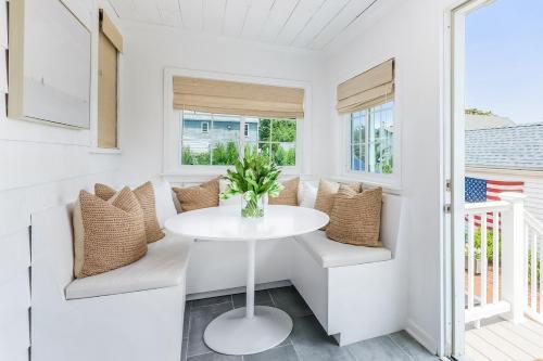 a white dining room with a white table and chairs at Stay at Black Rock Harbor in Bridgeport