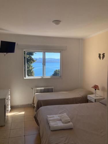 a bedroom with two beds and a window at Hotel Costa del Lago in San Carlos de Bariloche