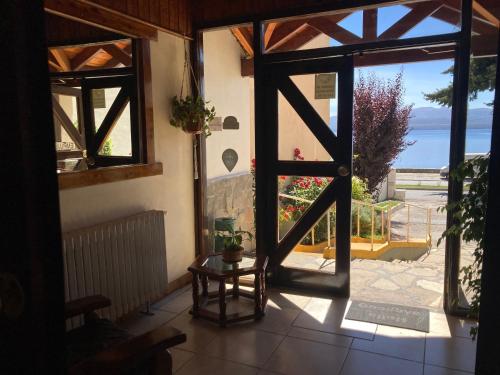 a door to a room with a view of the ocean at Hotel Costa del Lago in San Carlos de Bariloche