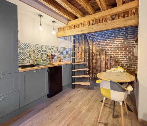 une cuisine avec une table et un mur en briques dans l'établissement Duplex cosy avec Netflix & Amazon prime, à Beauvais