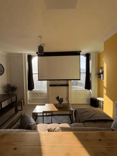 a living room with a couch and a fire place at Central Seaside Apartment with Home Cinema in Margate