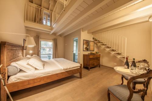 een slaapkamer met een groot bed en een trap bij B&B Antico Brolo in Gardone Riviera