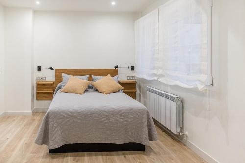 ein Schlafzimmer mit einem Bett und einem Fenster in der Unterkunft Espacioso apartamento a 9 min playa in Gijón