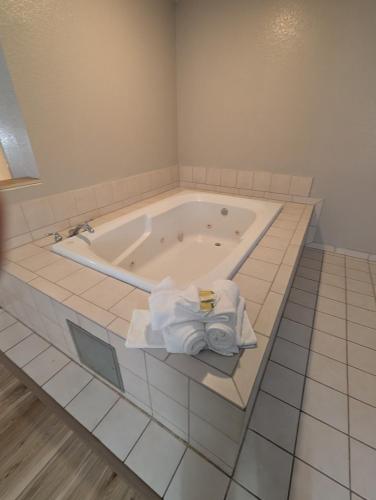 a bathroom with a tub with towels in it at Days Inn & Suites by Wyndham Castle Rock in Castle Rock