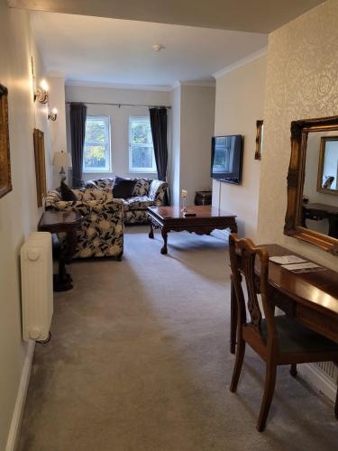 a living room with a table and a couch at Brook Hall Hotel in Childer Thornton