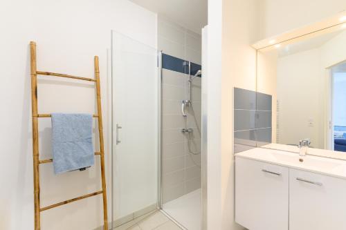 a white bathroom with a shower and a sink at Super appartement, la Guérinière à Noirmoutier in La Guérinière