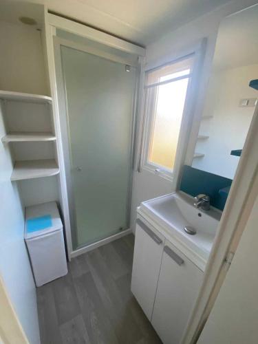 une salle de bain blanche avec un lavabo et une fenêtre dans l'établissement Camping 2 étoiles - Piscine - ccb0feg, à Villeneuve-lès-Maguelone