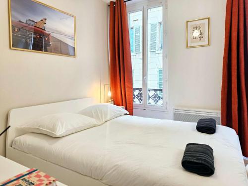 un lit blanc dans une chambre avec une fenêtre dans l'établissement Niala Studio in city center of Marseille at Vieux-Port and Opera, à Marseille