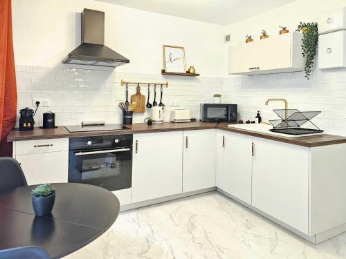 - une cuisine avec des placards blancs, un évier et une table dans l'établissement Niala Studio in city center of Marseille at Vieux-Port and Opera, à Marseille