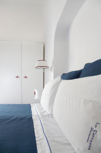 a bedroom with a bed with blue and white pillows at Hotel La Terrazza in Panarea