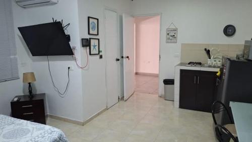 a room with a room with a bed and a kitchen at Ingenio Park 83 - Apartahotel in Cali