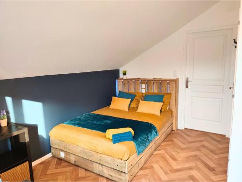 - une chambre dotée d'un lit avec des draps jaunes et bleus dans l'établissement 4 studios - Musique en Champagne, à Châlons-en-Champagne