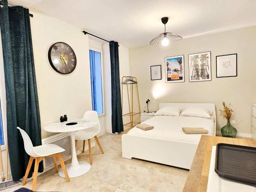 un salon avec un canapé blanc et une horloge au mur dans l'établissement Rise Studio in city center of Marseille at Vieux-Port and Opera, à Marseille