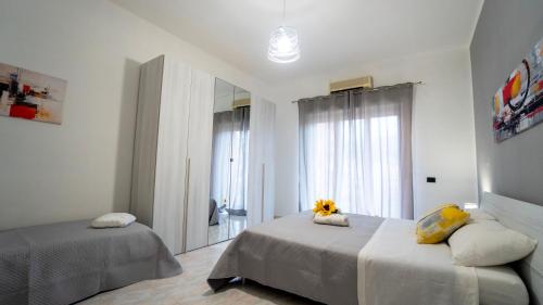 a bedroom with two beds and a mirror at Policlinic House Messina in Messina