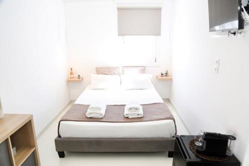 a small bedroom with a bed with towels on it at Heart of the City Studios in Mýkonos City