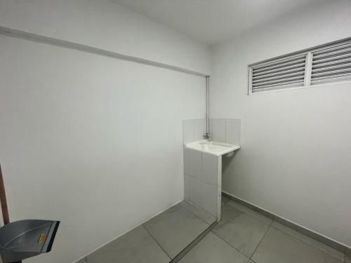 a white bathroom with a sink and a window at Ingenio Park 83 - Apartahotel in Cali