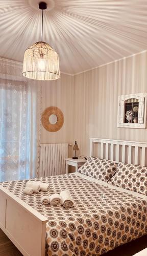 a bedroom with a large bed with a chandelier at B&B Casa Dolce Casa Monopoli in Monopoli