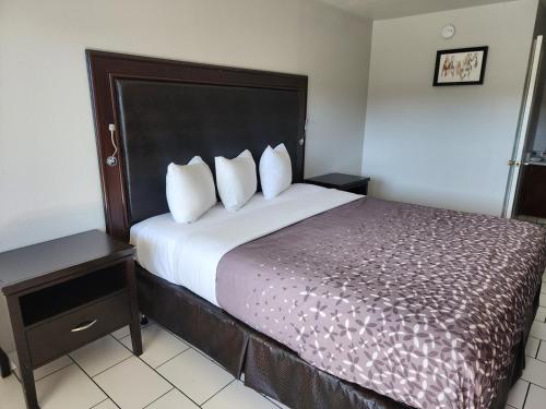 a hotel room with a large bed with two pillows at Pacific Inn in Crescent City