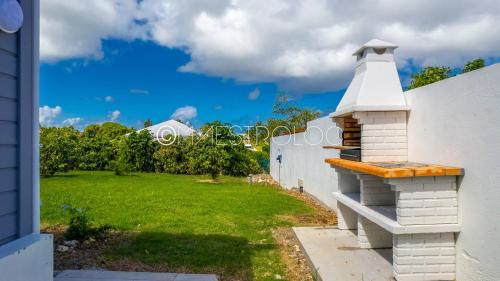 a white building with a lighthouse on the side of a yard at Offre à ne pas rater ! Gîtes Arc-en-ciel in Saint-François
