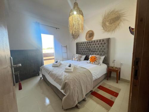 a bedroom with a large bed with towels on it at Apartment haut standing in Ghazoua