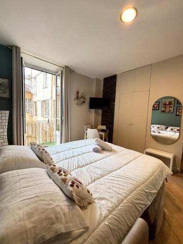 deux lits dans une chambre avec une grande fenêtre dans l'établissement studio plein centre ville rue piétonne, à Nice