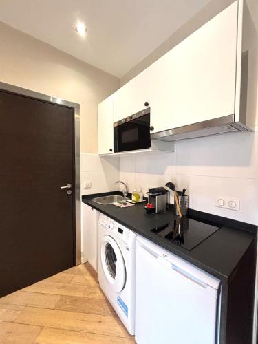 une cuisine avec un lave-linge et un micro-ondes dans l'établissement studio plein centre ville rue piétonne, à Nice
