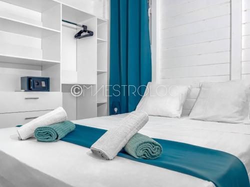 a bedroom with a bed with towels on it at Offre à ne pas rater ! Gîtes Arc-en-ciel in Saint-François
