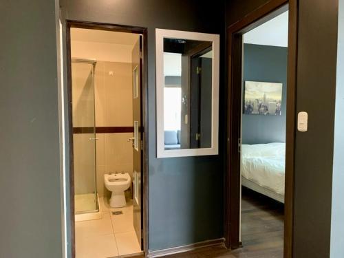 a bathroom with a shower and a toilet and a bed at Joseva 302 in Río Gallegos