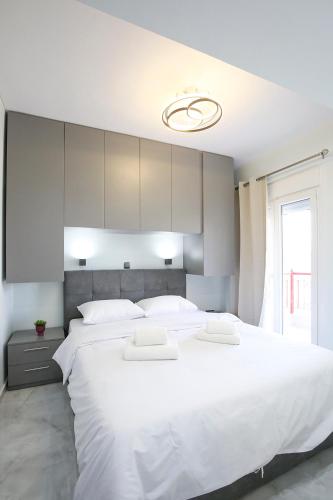 a bedroom with a large white bed with white pillows at #Ioanna Apartments Unique in Thessaloniki