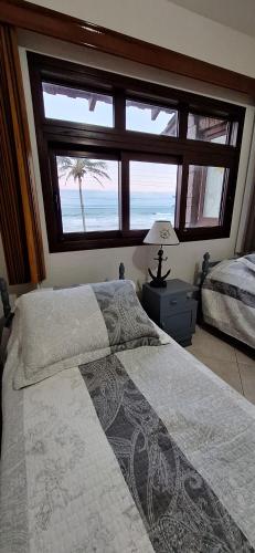 a bedroom with a bed with a view of the ocean at Amanhecer dos Sonhos in São Francisco do Sul