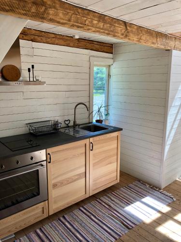 a kitchen with a sink and a stove at Humlesten's Gård in Huaröd
