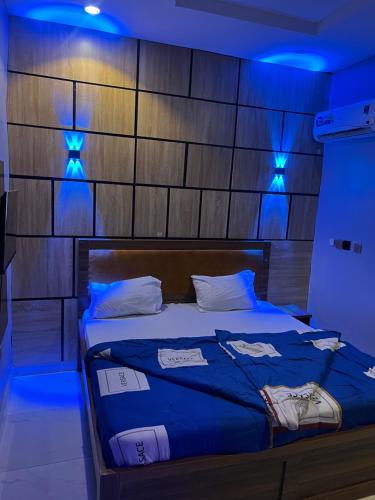 a bedroom with a bed with blue lights on it at Destymond Apartment warri in Warri