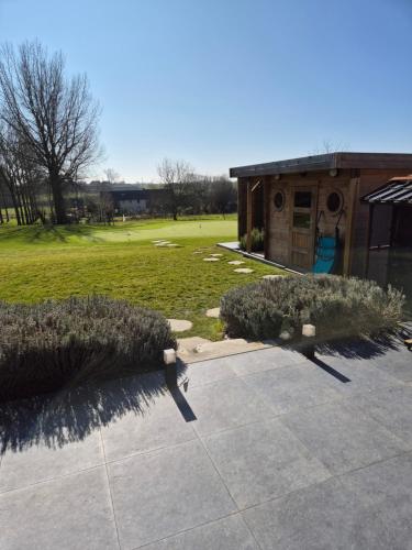 a yard with a building and some bushes at Le Paradis d'Henri in Hannut