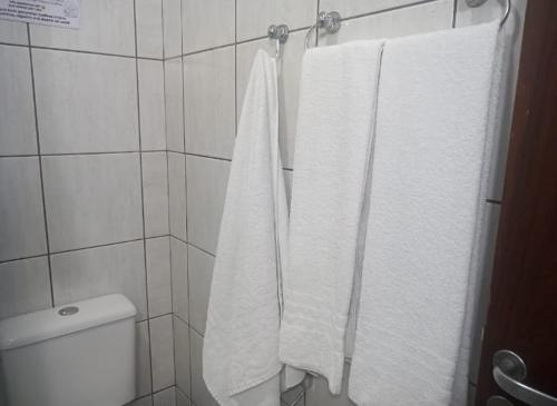 a bathroom with white towels hanging on a rack at Apê Aconchego Calhau - 3 Minutos de Carro da Praia in São Luís