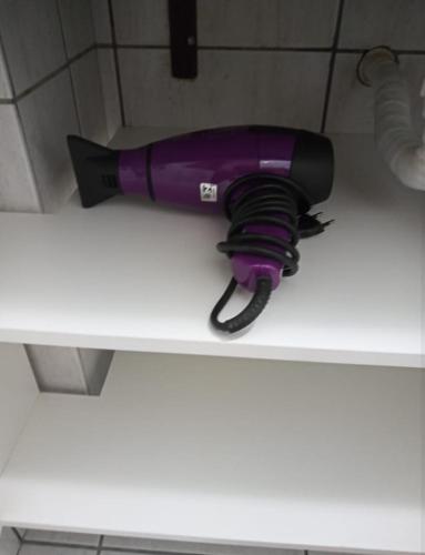 a purple blow dryer sitting on a counter at Apê Aconchego Calhau - 3 Minutos de Carro da Praia in São Luís