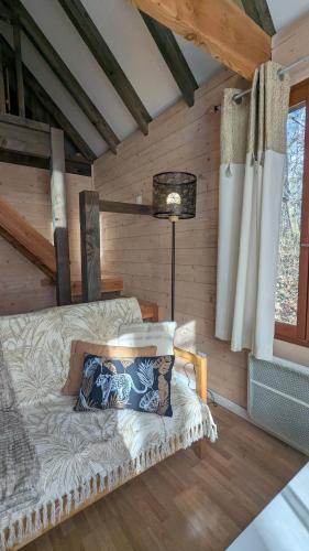 une chambre avec un lit et une lampe dans une cabine dans l'établissement chalet Vital avec Spa privatif, à Biron