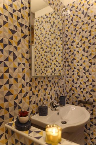 a bathroom with a sink and a mirror and candles at Casa Giudea in Brindisi