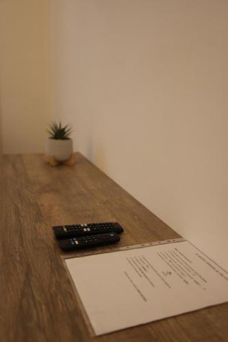 two remote controls sitting on top of a wooden table at Casa Giudea in Brindisi