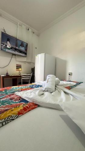 a bedroom with a white bed with a refrigerator at Pousada Iracema Centro in Fortaleza