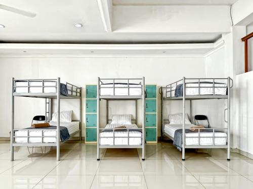 three bunk beds in a room with white walls at Kasih HomeStay Banyuwangi Mount Ijen Crater in Banyuwangi